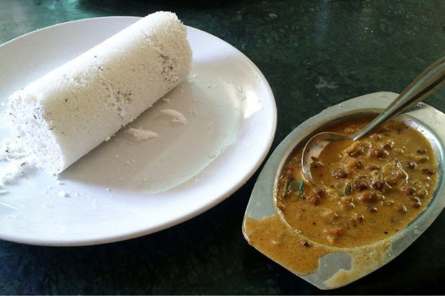 Traditional Kerala breakfast Puttu and Kadala Curry served on banana leaf during Kerala food tour package